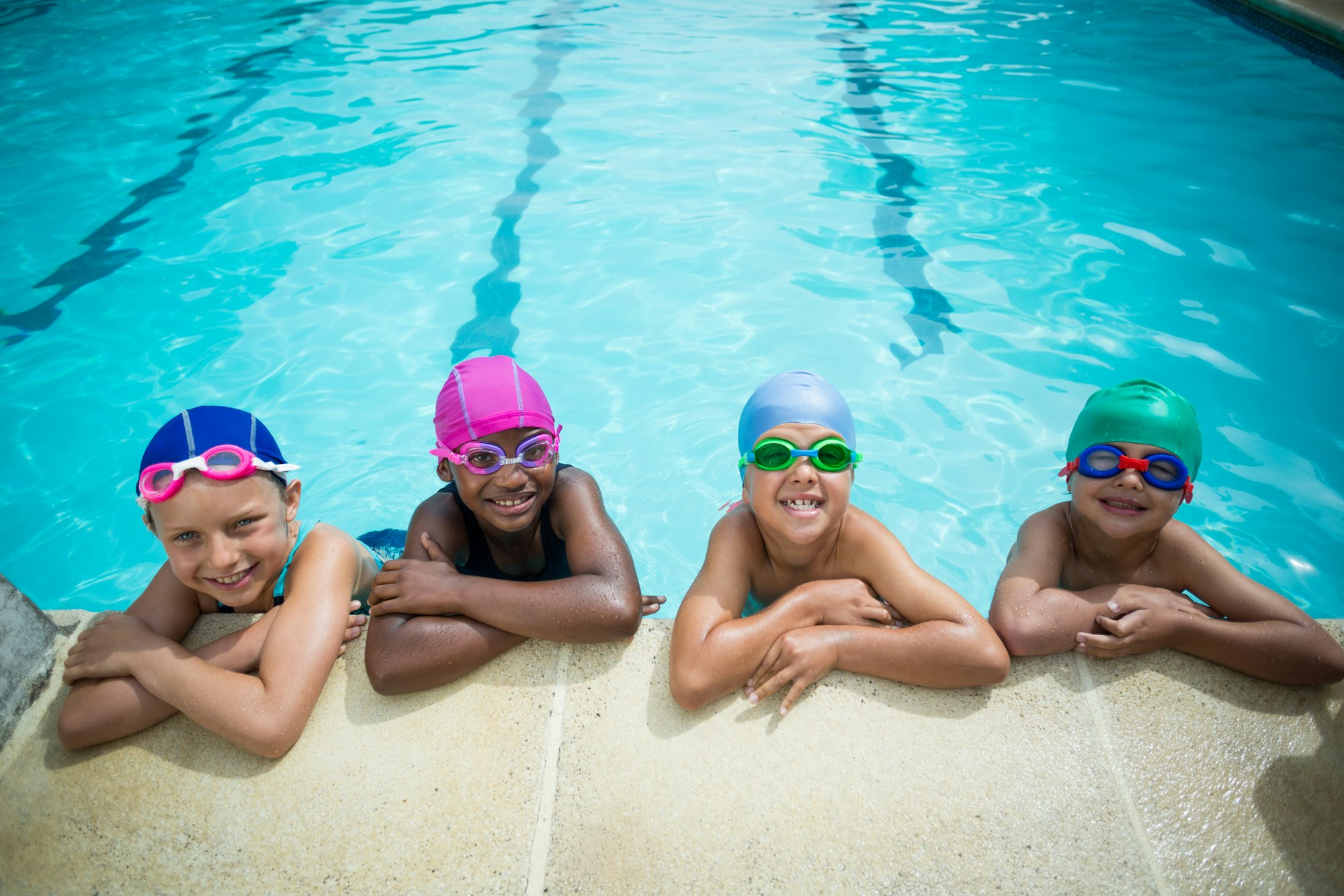 Little swimmers leaning at poolside