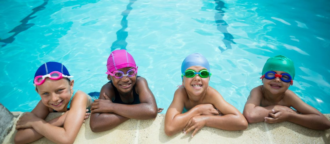 Little swimmers leaning at poolside